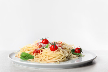 Tasty pasta on light grey marble table against white background