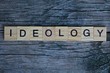 ideology word from wooden letters lies on a gray blackboard
