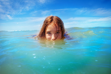 Wall Mural - Half underwater portrait of a girl swim in the sea