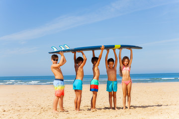 Wall Mural - Five kids with surfboard on the sand sea beach