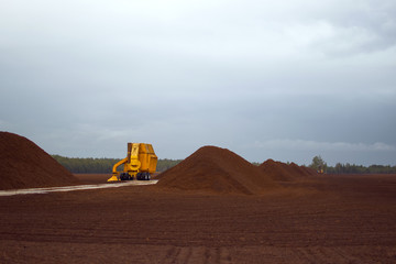 Peat or turf production: machine harvesting peat on the field 