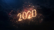 2020 Happy New Year Greeting Text With Particles And Sparks On Black Night Sky With Colored Fireworks On Background, Beautiful Typography Magic Design.