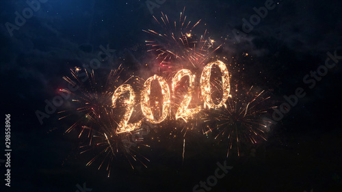 Cuadros en Lienzo 2020 Happy New Year greeting text with particles and sparks on black night sky with colored fireworks on background, beautiful typography magic design