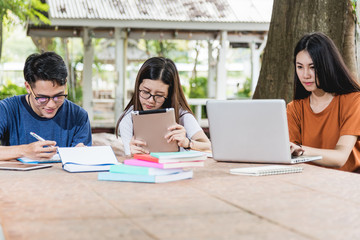 Wall Mural - Man students and girlfriend are consult information from computer laptop, tablet and book outdoor