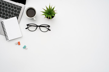 Wall Mural - Work space office business and finance concept on white table desk background with laptop computer and coffee cup, green plant and glasses, Top view with copy space, flat lay