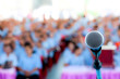© Amnat - Focus at microphone over the blurred business conference hall or seminar room, Blurred background.