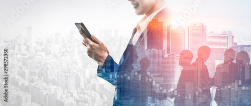 Fotografía Double Exposure Image of Business Communication Network Technology Concept - Business people using smartphone or mobile phone device on modern cityscape background