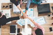 © InfiniteFlow - Businessmen and businesswomen joining hands in group meeting at multicultural office room showing teamwork, support and unity in business. Diversity workplace and corporate people working concept.