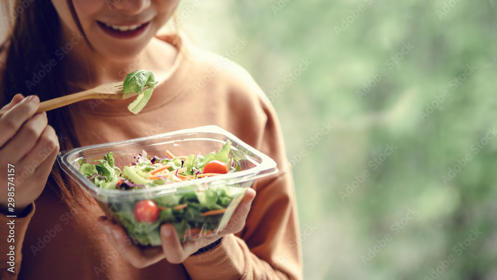Closeup woman eating healthy food salad, focus on salad and fork. - obrazy, fototapety, plakaty 