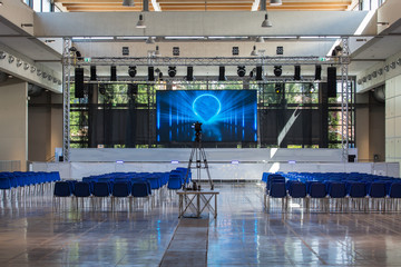 Empty Conference Room Equipped with Stage, Lights, Chairs and Professional Camera