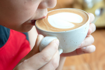 woman is drinking art latte coffee