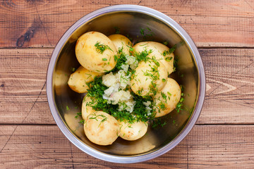 young raw potatoes with herbs for baking in the oven, top view, selective focus