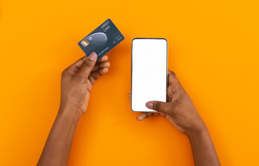 Smartphone with blank screen and credit card in female hands