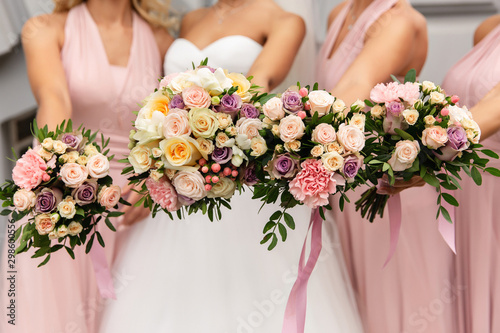 Cuadros en Lienzo Bride and bridesmaids in pink dresses posing with bouquets at wedding day