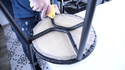 Wall Mural - Worker with screwdriver assembling the chair