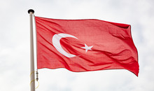 Turkish Flag Waving Against Cloudy Sky Background