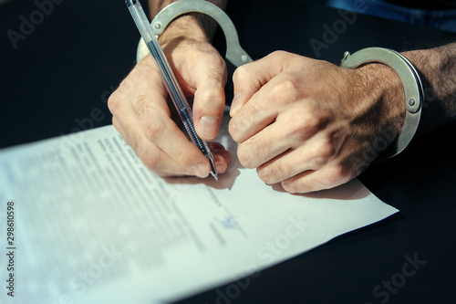 Fotografía Men's hands in handcuffs. Plea agreement