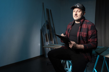 Aufkleber - joiner. a man with a tablet and a pencil in his hands. the man looks at the camera. the master comes
