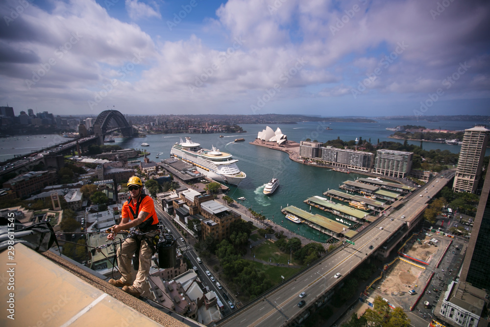 Male rope access repaire wearing t-shirt using static twin rope ...