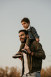 © Olena Bloshchynska - Father giving son ride on his shoulders during walking in autumn park.