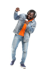 Wall Mural - Handsome African-American man listening to music on white background