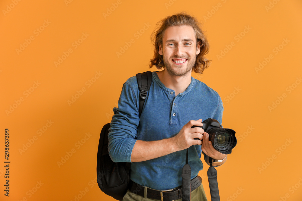 Young male photographer on color background