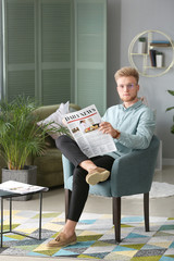 Sticker - Portrait of stylish young man with newspaper resting at home