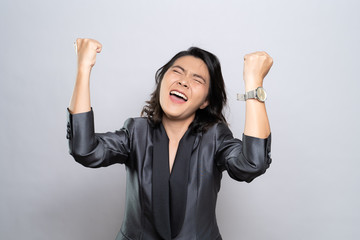 Happy woman make winning gesture isolated over white background