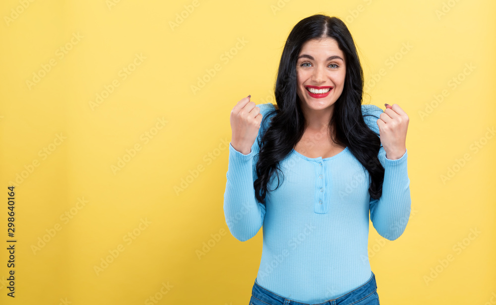 Successful young woman on a yellow background - obrazy, fototapety, plakaty 