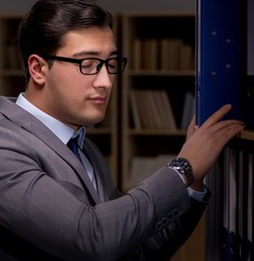 Businessman almost falling asleep working late hours in the offi