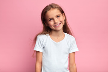 cheerful blonde girl in white t-shirt looking at the camera with positive expression. close up portr