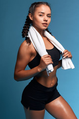 Wall Mural - young sexy slim athlete having rest after workout. close up photo.leisure, free time, spare time. close up photo. isolated blue background