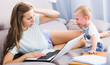 © JackF - Perplexed woman is having problems with work while kid crying