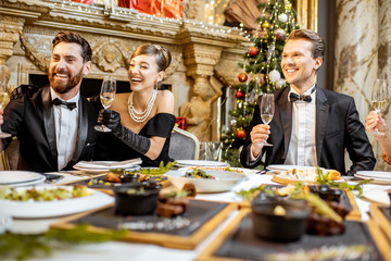 Wall Mural - Elegantly dressed people having a festive dinner indoors