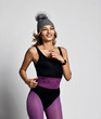 © Dmitry Lobanov - Portrait of young athletic woman in purple sports wear and gray winter hat with furry pompon enjoying running  jogging