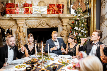 Wall Mural - Elegantly dressed people having a festive dinner indoors