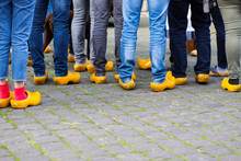 Close Up Of Blue Jeans Legs Of Group Of People Wearing Traditional Wooden Clogs During Guided City Tour - Xanten, Germany