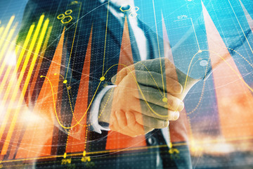 Double exposure of financial chart on cityscape background with two businessmen handshake. Concept of financial analysis and investment opportunities