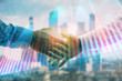 © Andrey - Double exposure of financial graph on cityscape background with two businessman handshake. Concept of stock market deal