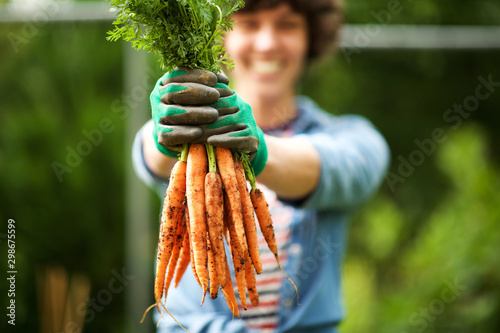 Fotografía Close up gardener with bunch of carrots in hand in garden