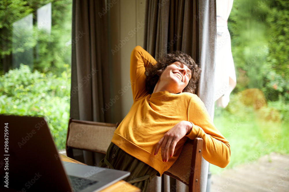 woman relaxing at home looking out of window - obrazy, fototapety, plakaty 