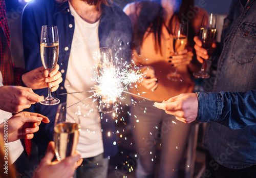 Fotografía Group of happy people holding sparklers at party and smiling