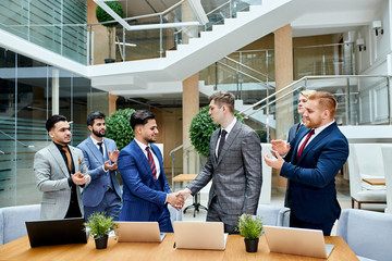 Wall Mural - Representatives of arabian and caucasian countries shaked hands to each other after successful meeting, came to agreement. Other leaders behind applaud