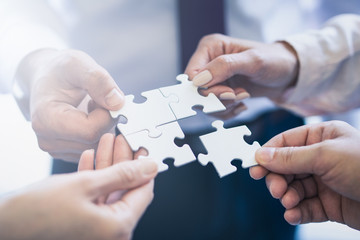 A group of business people assembling jigsaw puzzle.