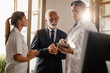 © Drazen - Mature businessman and male doctor working on digital tablet at medical clinic.