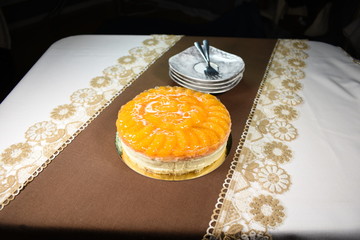 Cheese cake with cream and tangerines. On a white brown background