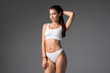 © F8  \ Suport Ukraine - Young beautiful woman body on gray background in white sport clothes