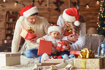 The family gives gifts to the child in the room in Christmas