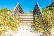 Wooden Stairs Over Sand Dune And Grass At The Beach In Florida USA