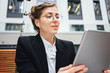 © leonidkos - Handsome female freelancer wearing glasses using digital tablet for working on project in social media. Business lady talking on wireless headphone and hold in hand professional designer pad computer